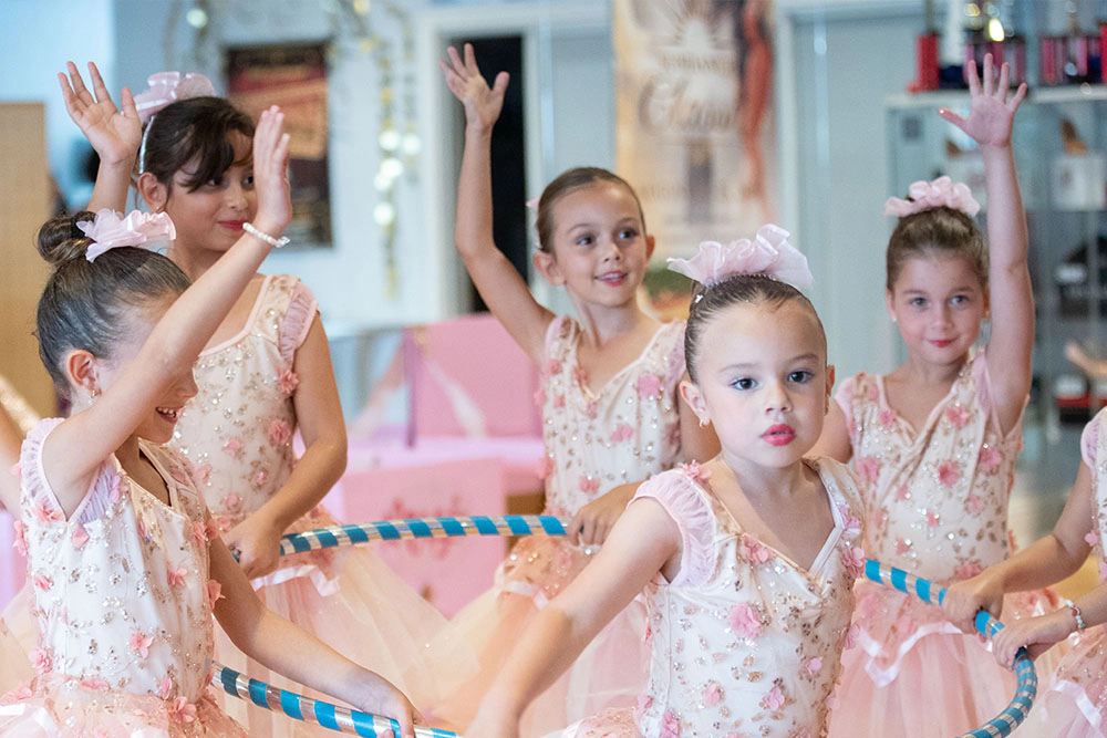 a group of little girls from a ballet class performing together wearing pink tutus