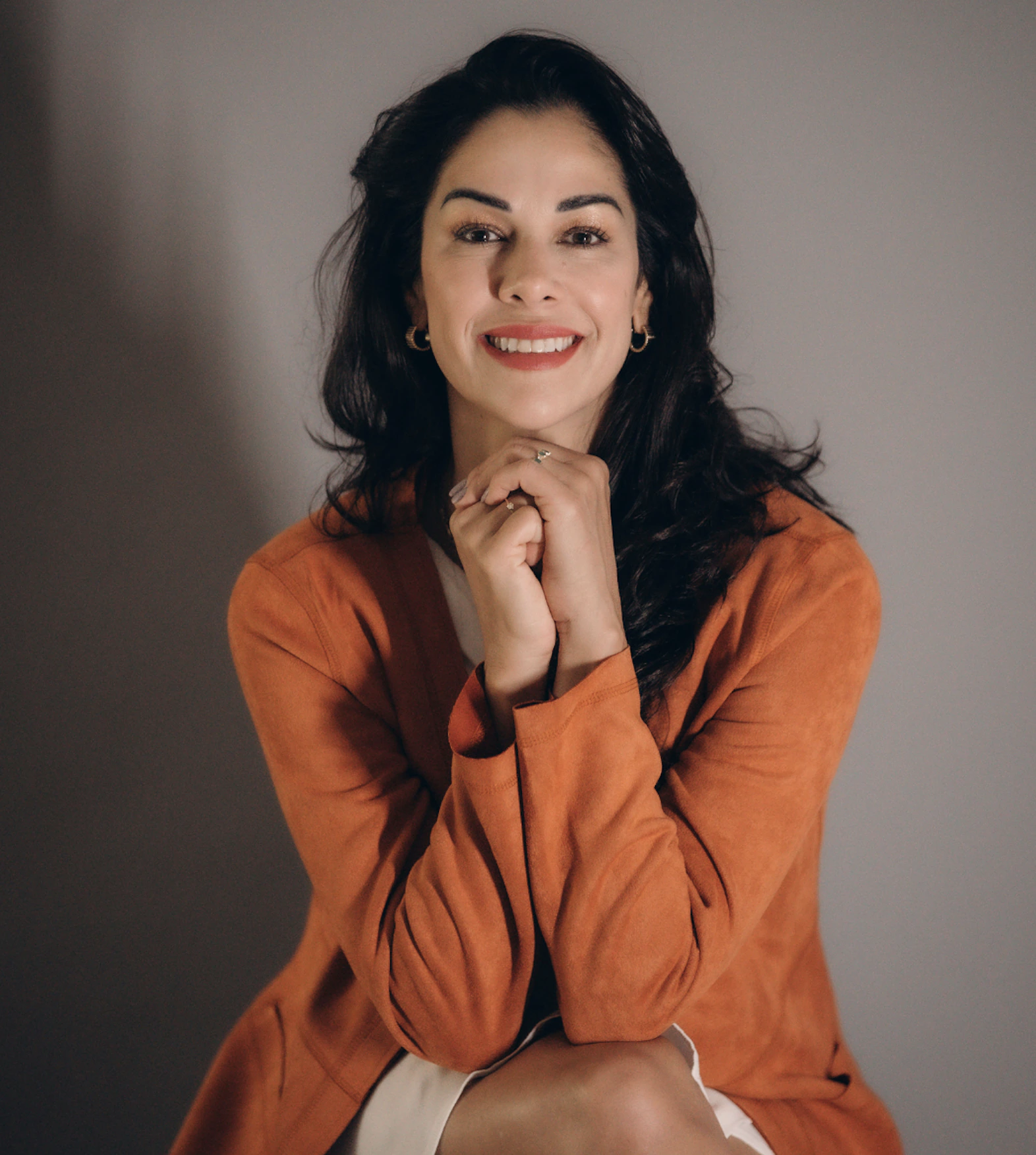 Ludmilla Fleury wearing a orange shirt and smiling