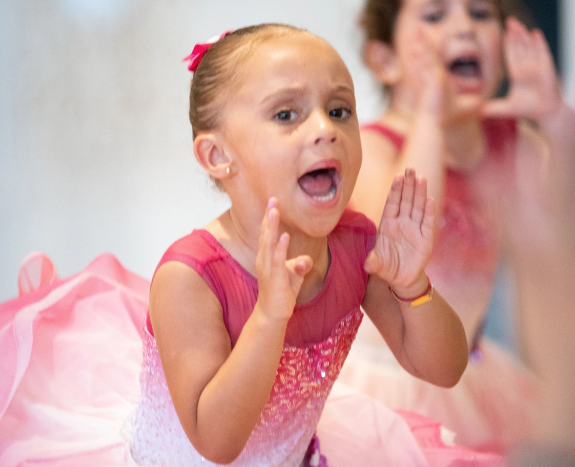 two little girls in ballet costumes shouting during a performance